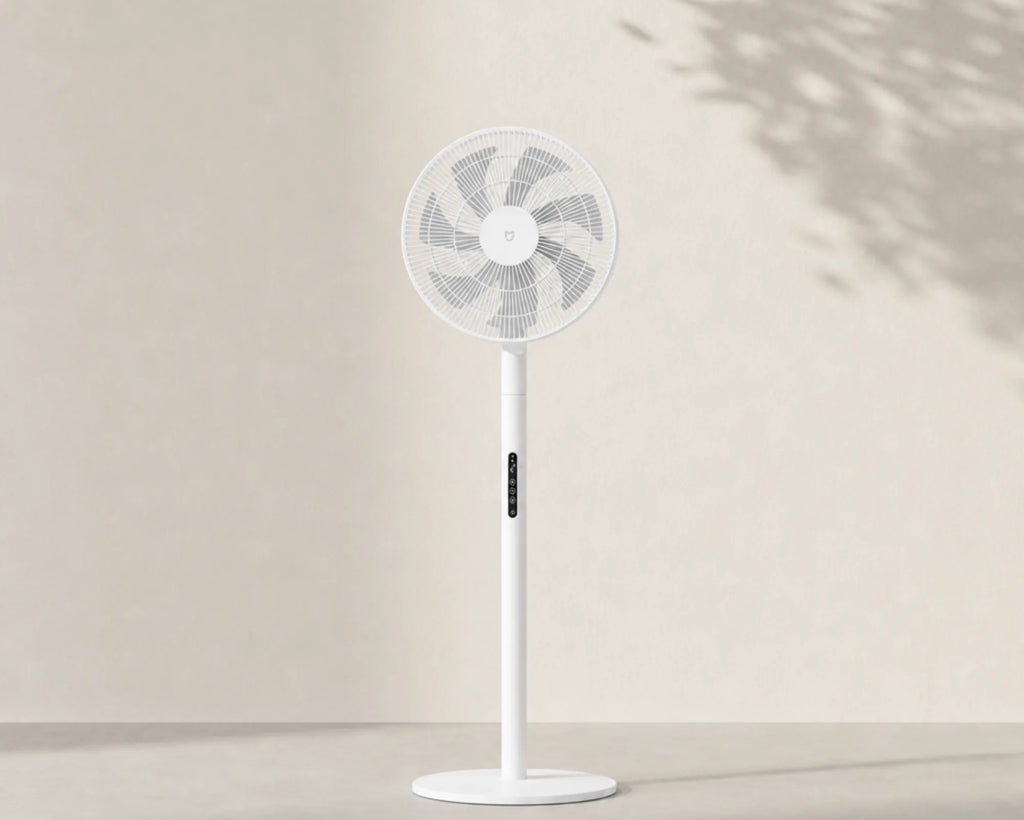 Ventilateur sur pied silencieux DC blanc sur fond ivoire épuré avec ombre végétale L'Air Sain